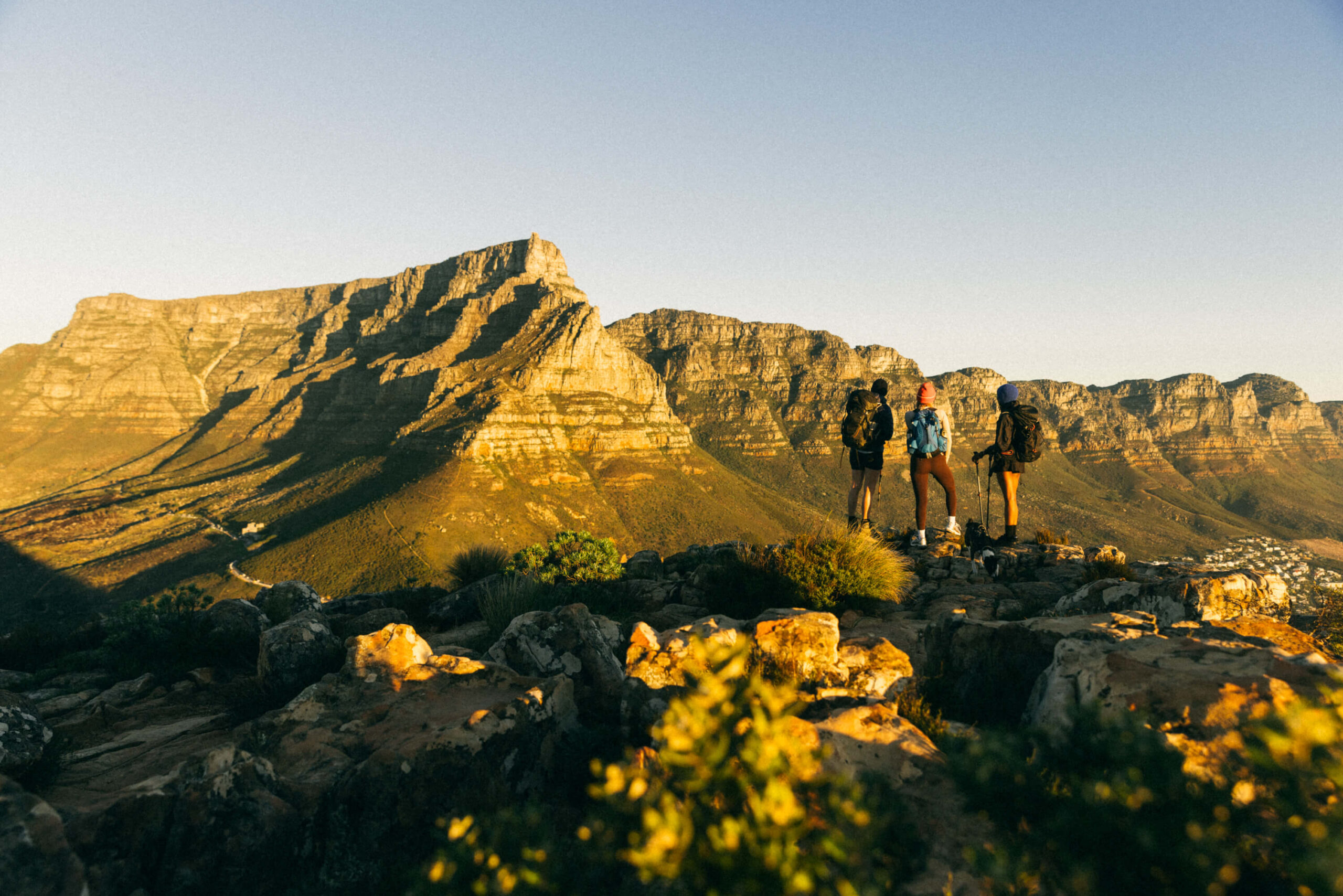 three hikers standing on Lion's Head looking towards Table Mountain